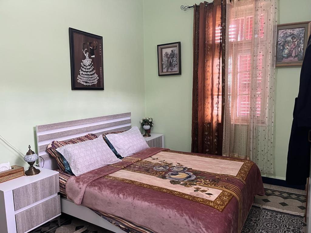 een slaapkamer met een groot bed en een raam bij Rosa Guest House in Haifa