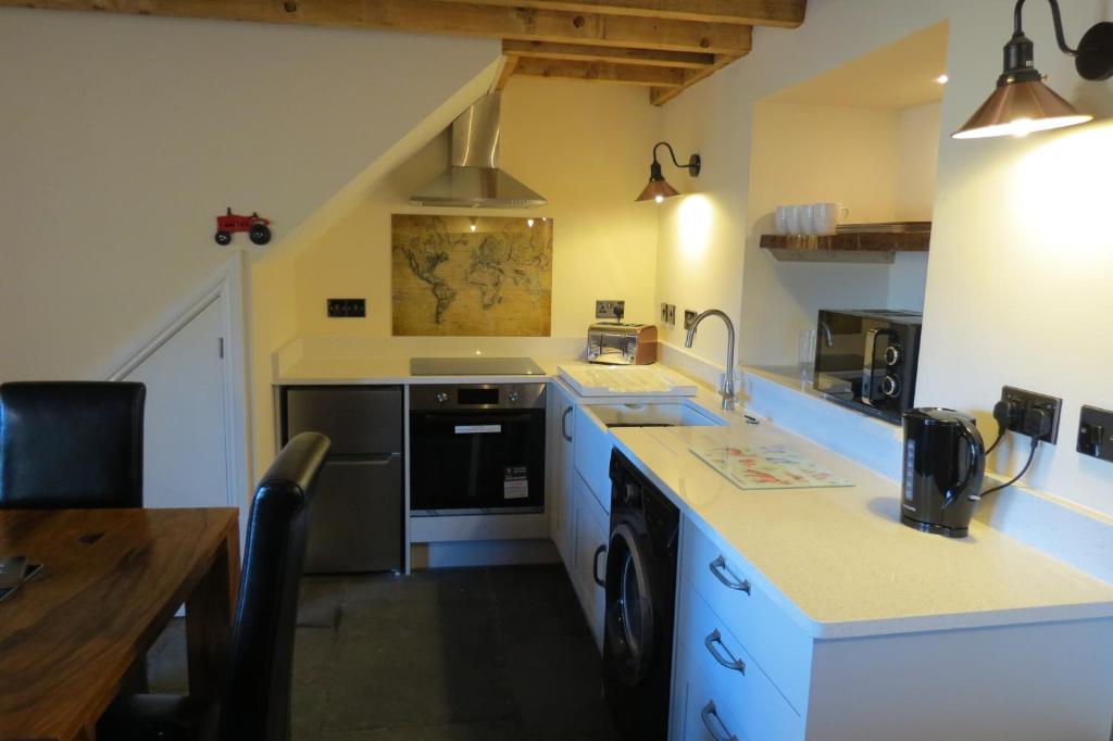 una cucina con lavandino e piano cottura di Farthing Cottage a Bishop Auckland
