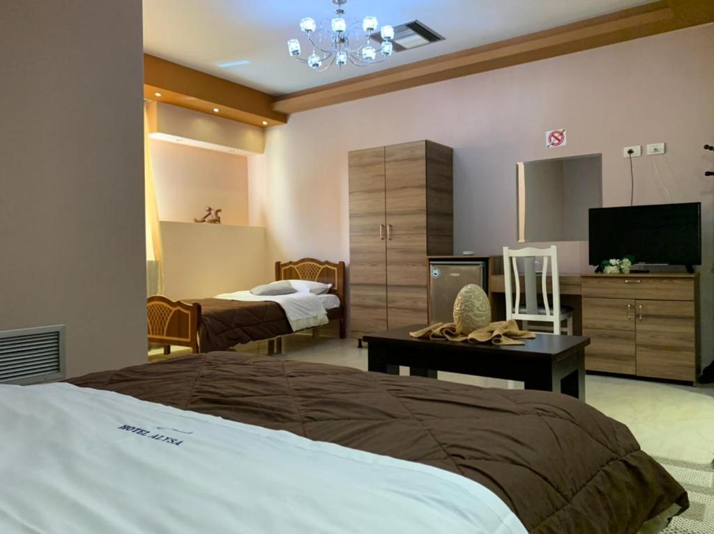 um quarto de hotel com duas camas e uma televisão em Hotel Alysa Korce em Korçë