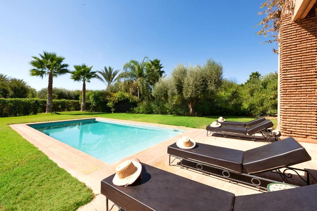 a swimming pool in a yard with a patio at Villa Selma avec piscine chauffée in Marrakesh
