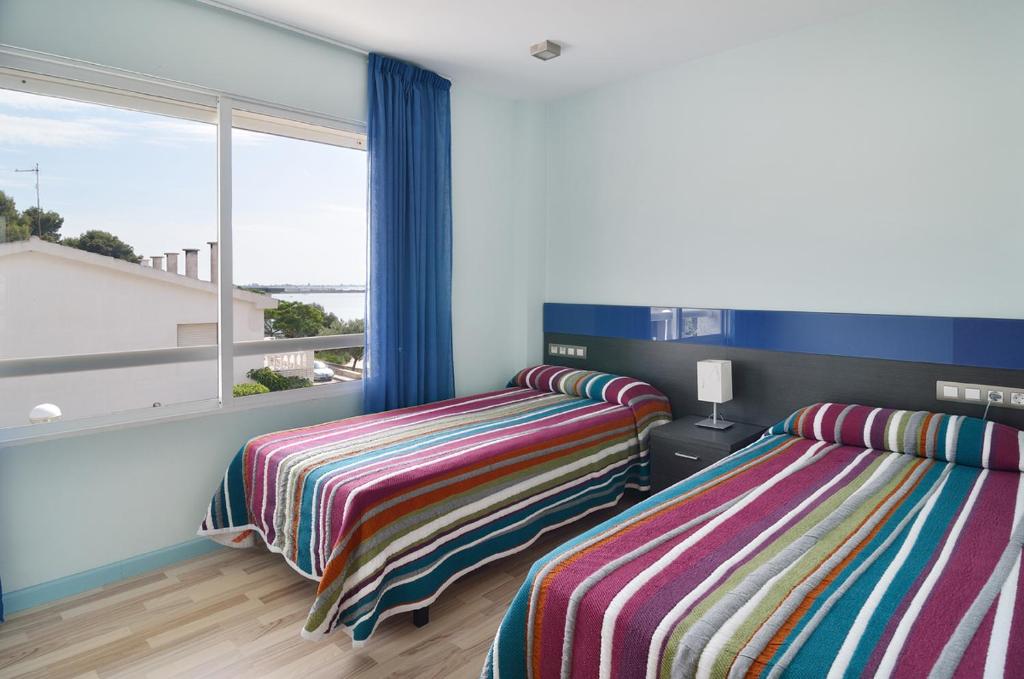 A bed or beds in a room at Ornis Apartments Platja