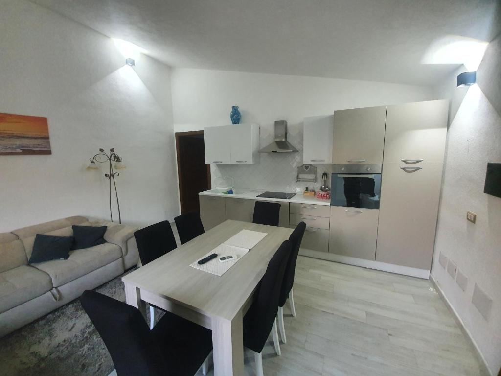 cocina y sala de estar con mesa y sofá en Appartamento Stangoni, en Badesi