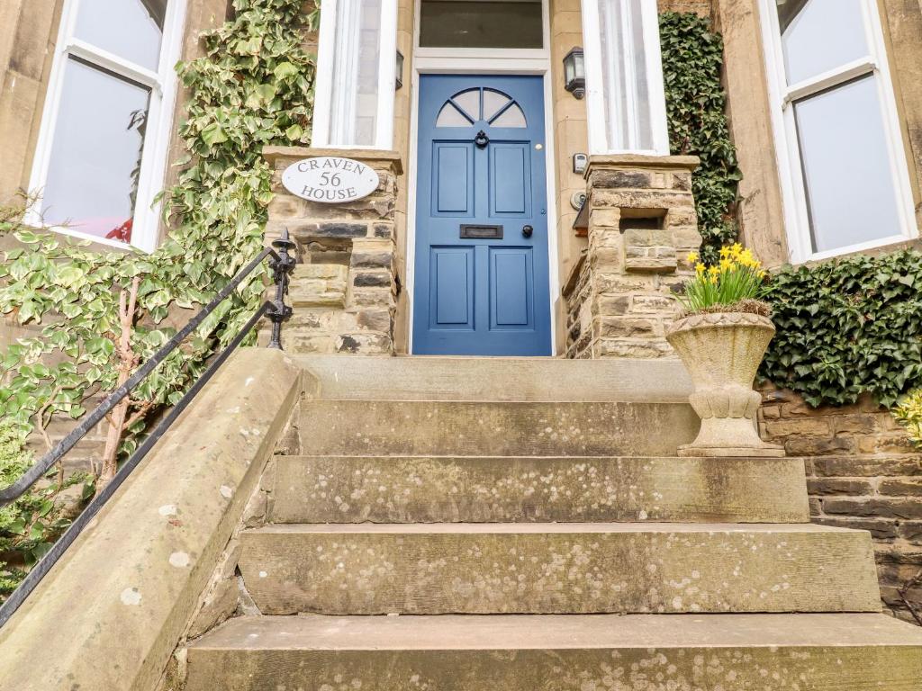 eine blaue Tür auf einem Haus mit Treppen in der Unterkunft Craven House in Skipton