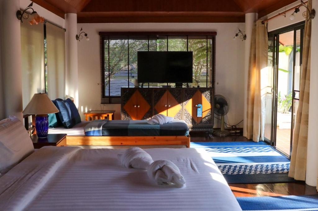 a bedroom with two beds and a flat screen tv at Casa Khaoyai Bed&Breakfast in Mu Si