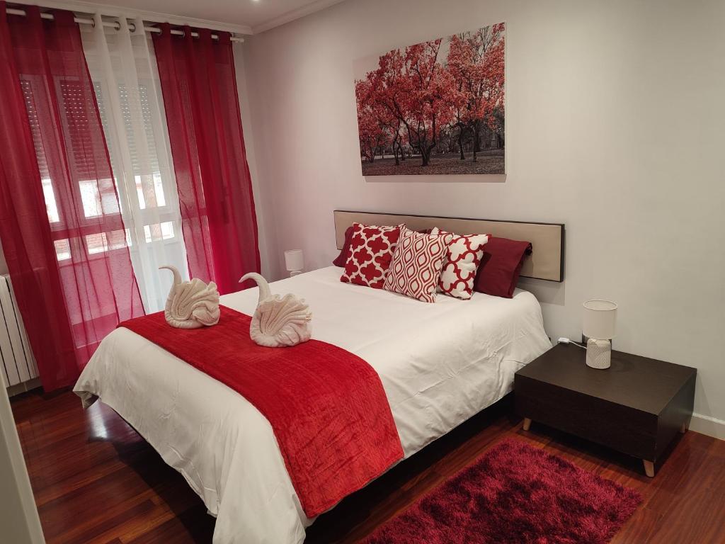a bedroom with a bed with a red blanket at O Fogar de Cati in Ourense