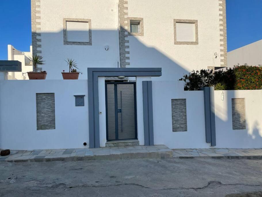a white building with a door with plants on it at Magnifique villa El Haouaria-Nabeul in El Haouaria