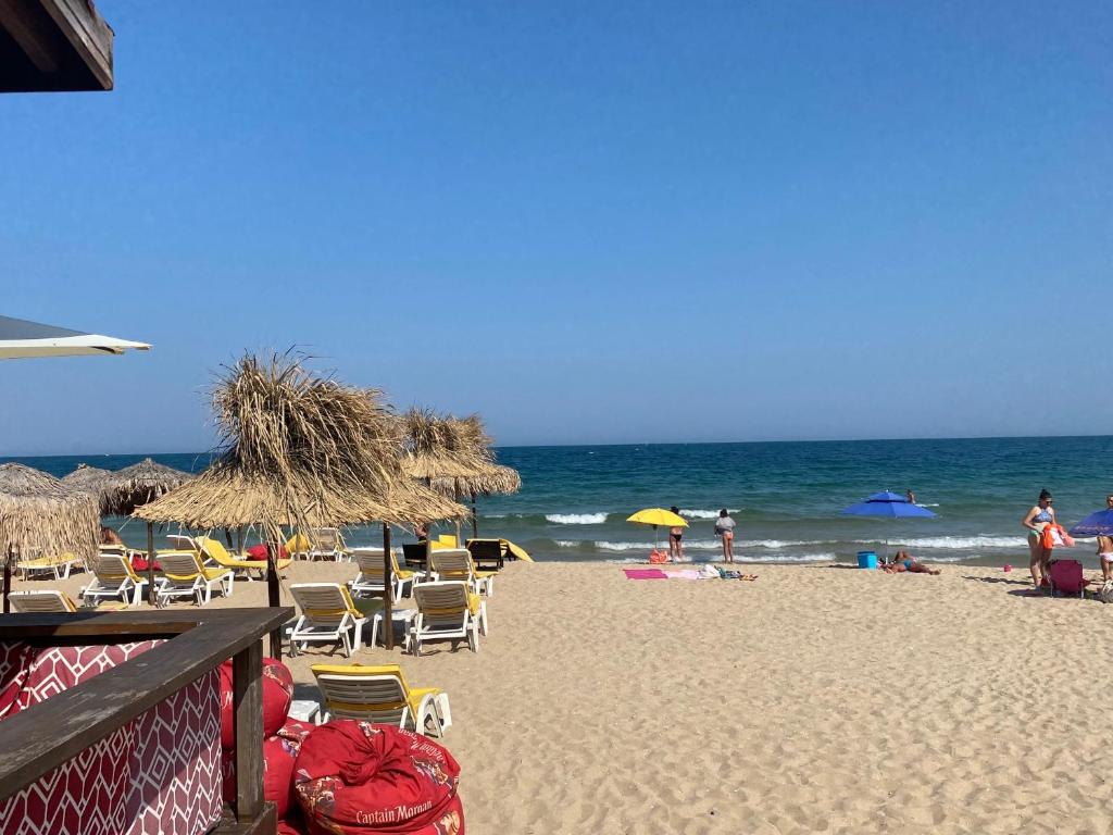 una spiaggia con sedie e ombrelloni e l'oceano di DESI HOUSE 302b Cozy Studio Nesebar a Nesebar