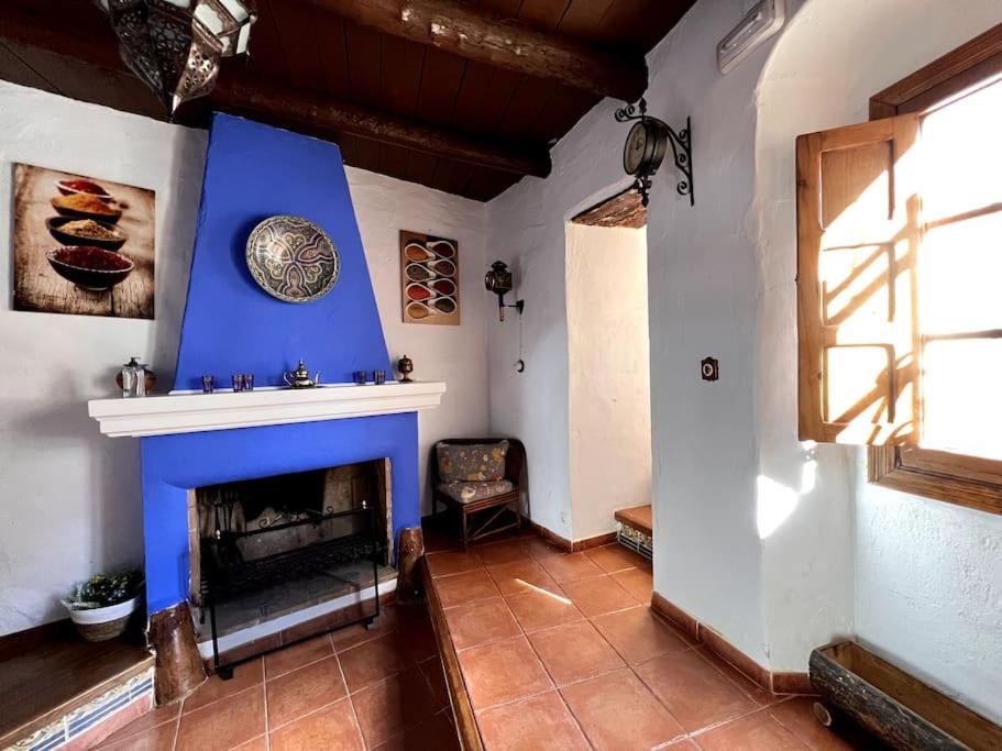 sala de estar con chimenea y manto azul en Casa La Fuente, en Jabugo