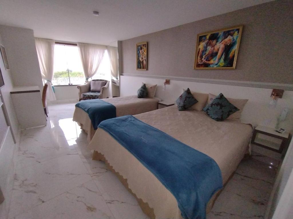 um quarto de hotel com duas camas e uma janela em Antonio's Hotel e Spa - Airport em Brasília