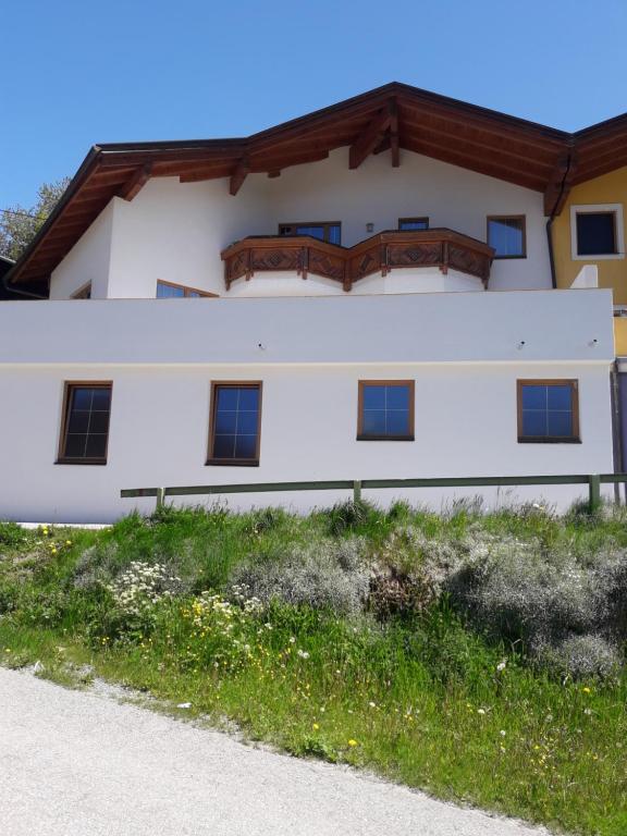 a white building with a wooden roof at Ferienhaus Kuenzerhof in Klaunz