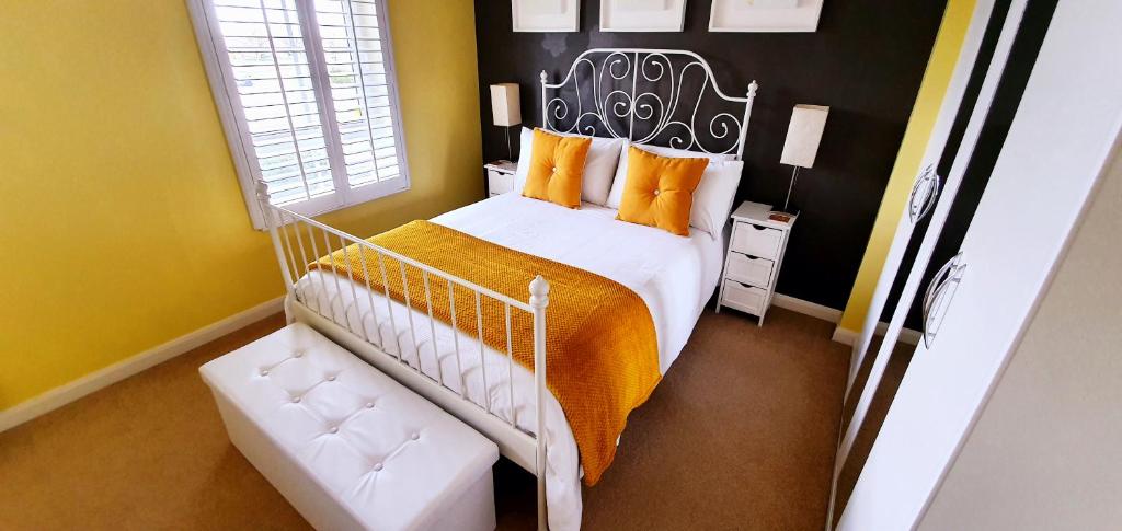 a bedroom with a large bed with orange pillows at Have it all.....City, Golf, Beaches & Countryside. in Prestonpans