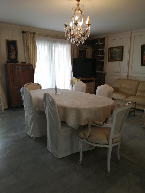 a dining room with a table and chairs and a chandelier at Cannes Mimosas One Bedroom in Cannes