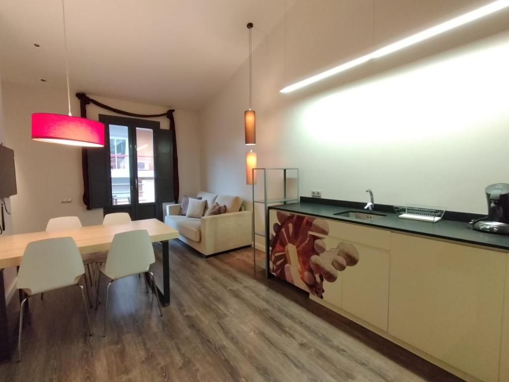 a kitchen and dining room with a table and chairs at Montserrat Apartments by gaiarooms in Barcelona