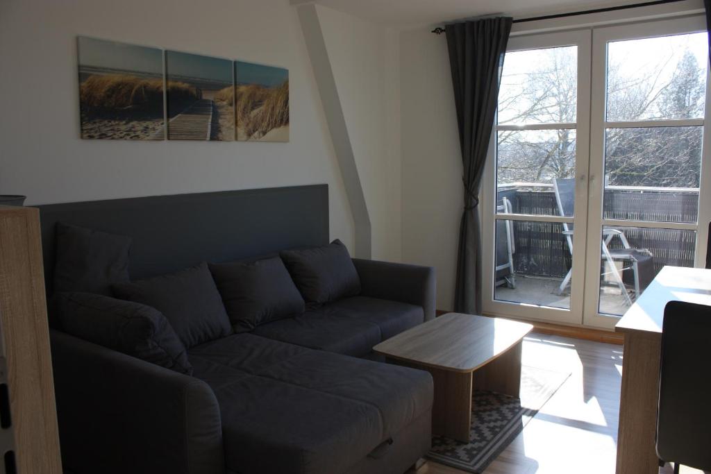 un soggiorno con divano e porta scorrevole in vetro di Ferienwohnung Breitling a Rostock