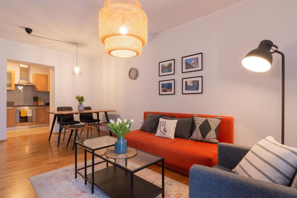 波雷奇的住宿－City Garden Apartment，客厅配有橙色沙发和桌子