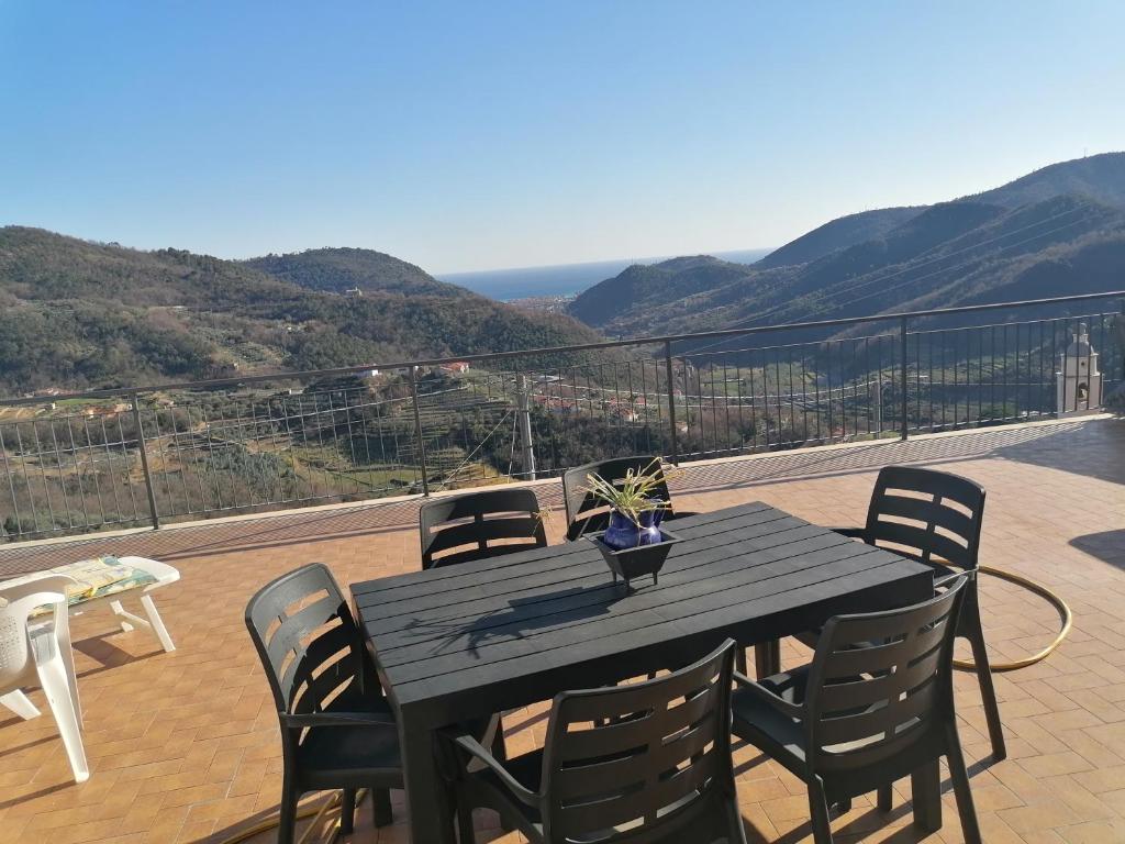 Casa di Anna في Tovo San Giacomo: طاولة سوداء وكراسي على شرفة مع الجبال