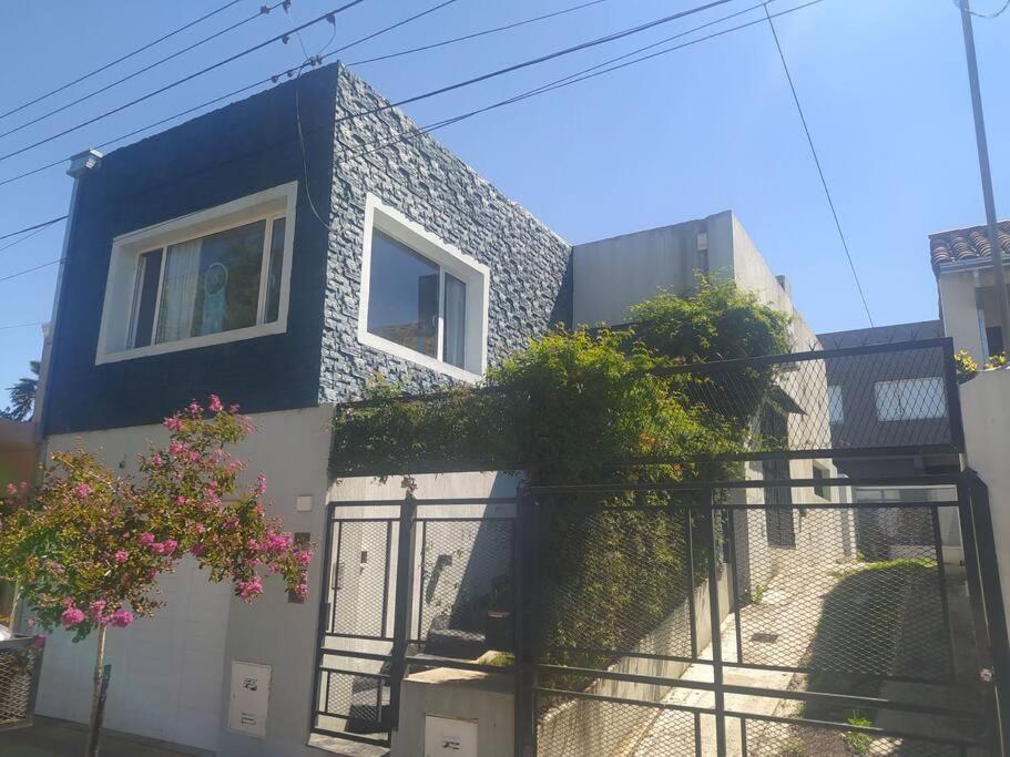 a blue and white house with a fence at Hermosa casa con patio, parrilla y garage cerrado in Tandil
