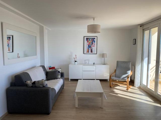 un salon avec un canapé et une table dans l'établissement CANNES Vue mer Parking Climatisation Chambre séparée, à Cannes
