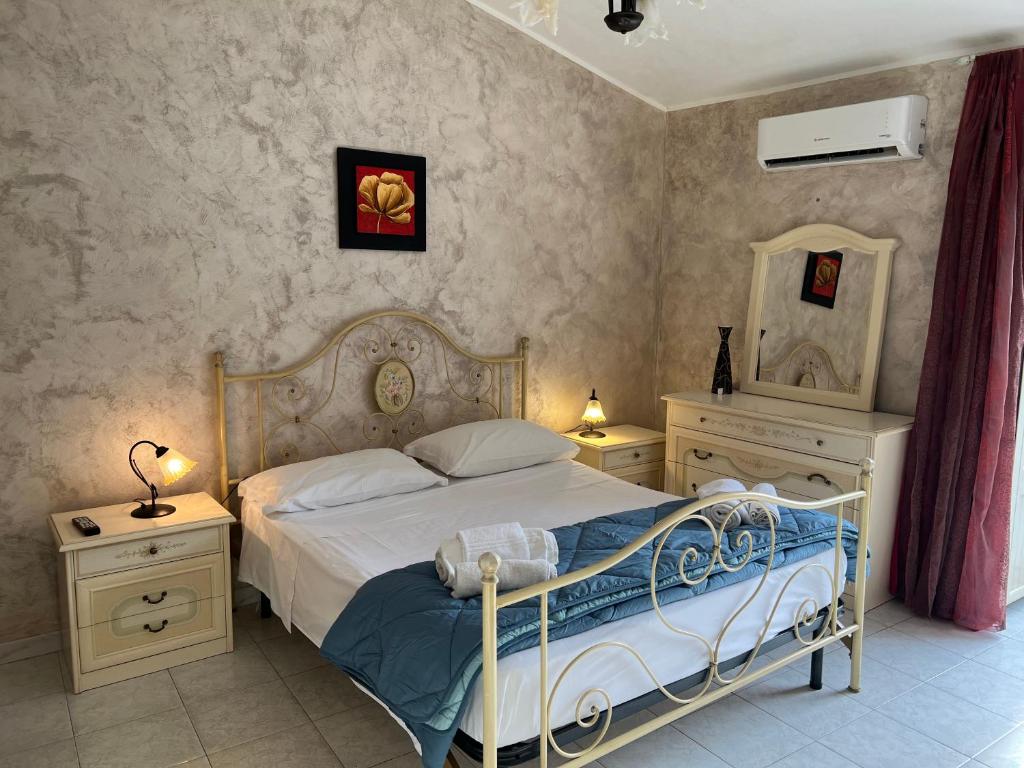 een slaapkamer met een bed, 2 nachtkastjes en een spiegel bij Perla in Cefalù