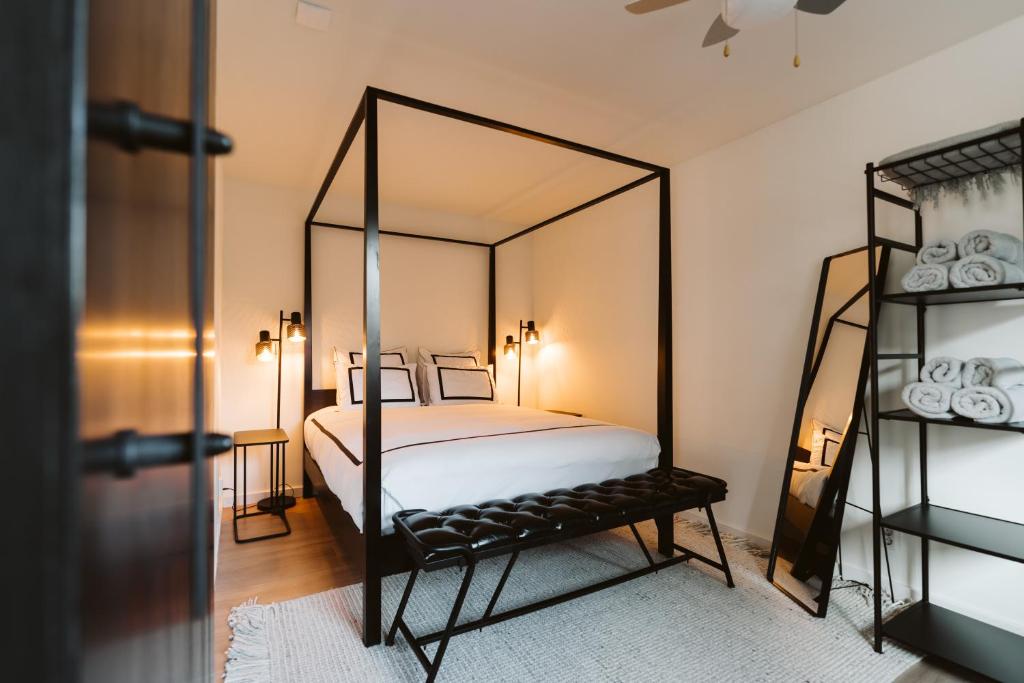 Appartement De Torenhoeve NIEUW في برغ هالمستاد: غرفة نوم مع سرير مظلة مع مرآة