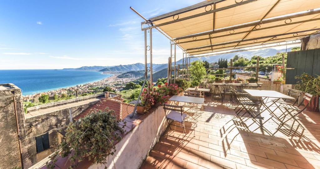 een patio met tafels en uitzicht op de oceaan bij San Martino Rooms & Breakfast in Borgio Verezzi