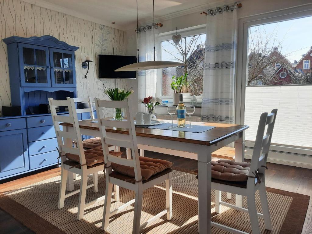 uma sala de jantar com uma mesa e cadeiras numa cozinha em Ferienwohnung Mühlennest em Emden