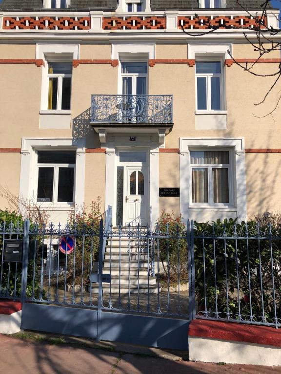 une clôture en face d'une maison avec terrasse couverte dans l'établissement Sainte Cécile 7 - T3 élégant et central, à Vichy