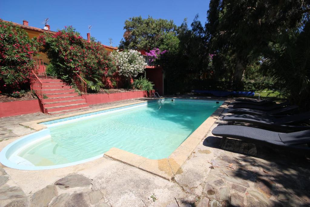 una piscina con tumbonas en un patio en Gîte les Mimosas des orgues de la Sybille, en Ille-sur-Têt