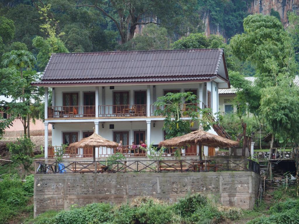 a white house with a black roof at Nam Ou River Lodge in Nongkhiaw
