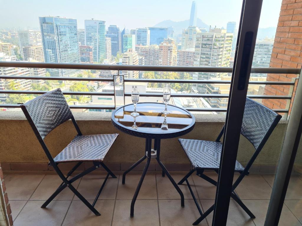 d'une table et de chaises sur un balcon avec vue. dans l'établissement Departamentos Pontoni Escuela Militar, à Santiago