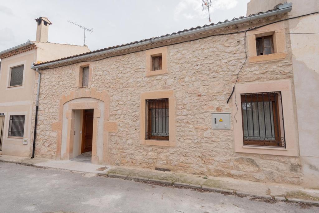 un antiguo edificio de piedra con una puerta en una calle en VuT El Pozo la Carrera 2, en San Pedro de Gaíllos