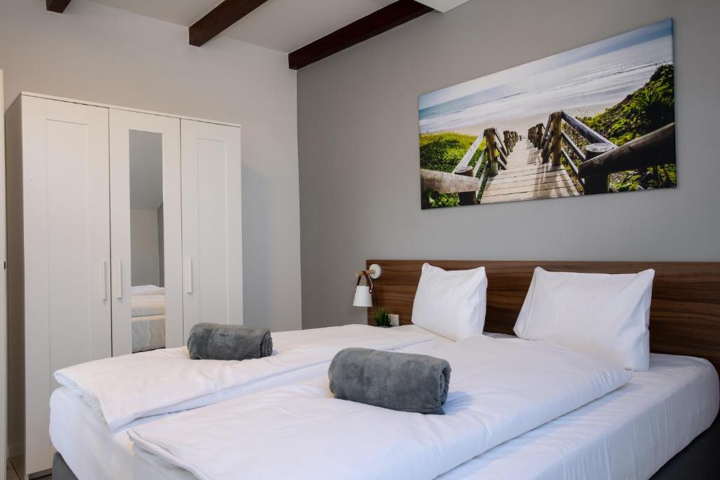 2 łóżka w pokoju z białymi ścianami w obiekcie JUNIPRO Apartments Bostalsee w mieście Bosen-Eckelhausen