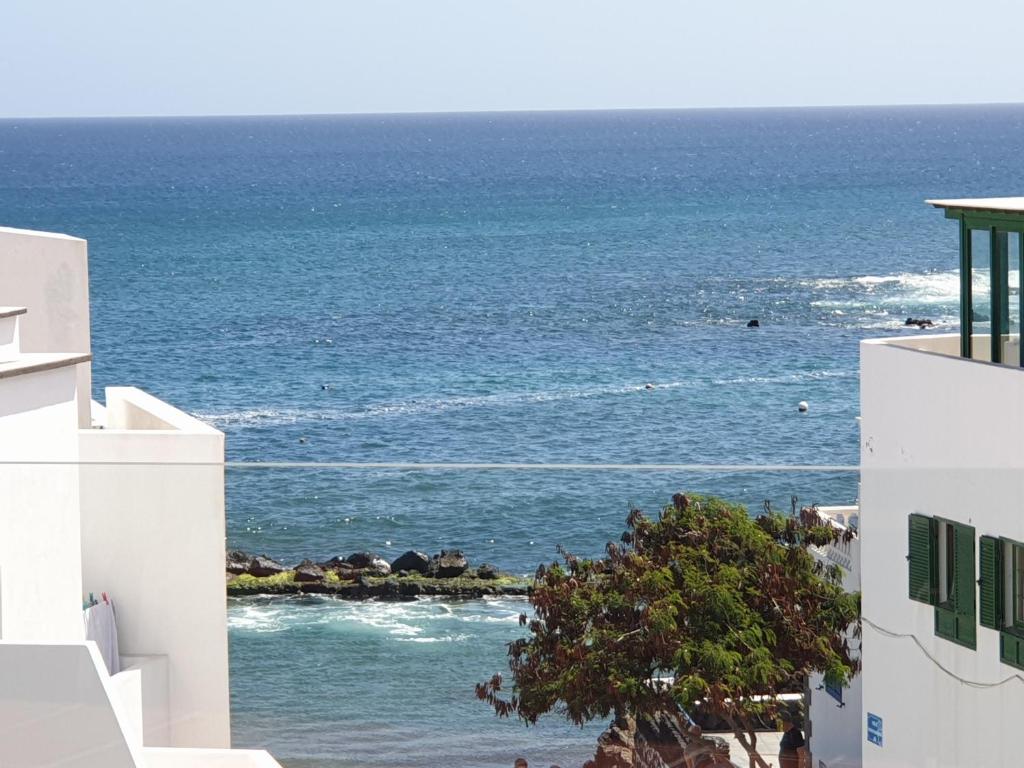 a view of the ocean from between two buildings at Apartamento Tabayba Arena in Punta Mujeres