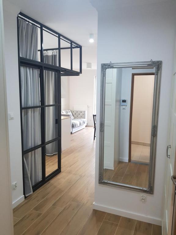 einen Spiegel an einer Wand in einem Zimmer mit einem Wohnzimmer in der Unterkunft Apartament na Starówce in Elblag