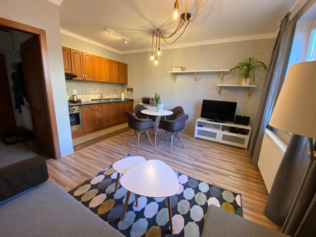 a living room with a table and chairs and a kitchen at Apartmán Pošta in Rajecké Teplice