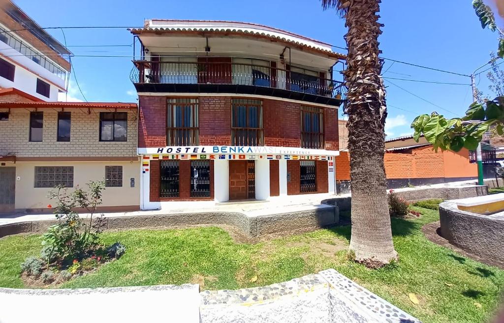 a building with a palm tree in front of it at Benkawasi Experience Huaraz in Huaraz