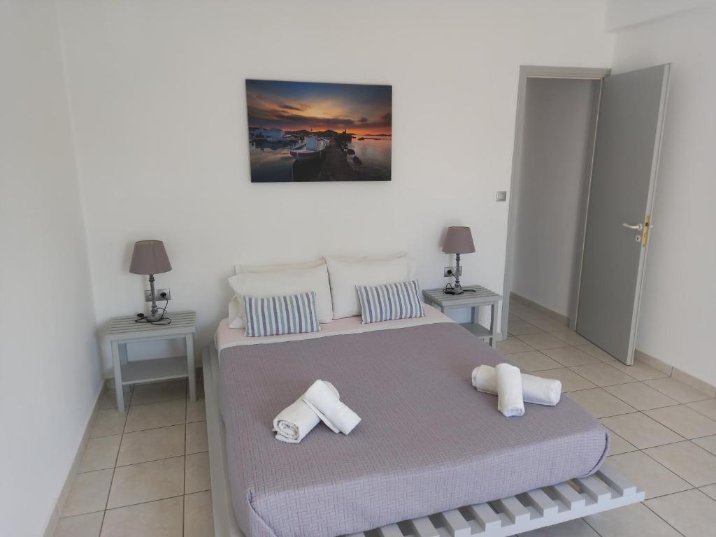 sypialnia z 2 łóżkami z poduszkami i obrazem na ścianie w obiekcie WONDERFULL SEA VIEW II w mieście Parasporos