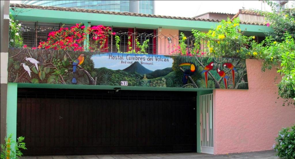 un edificio con un garaje con un cartel. en Hostal Cumbres del Volcán Escalón en San Salvador