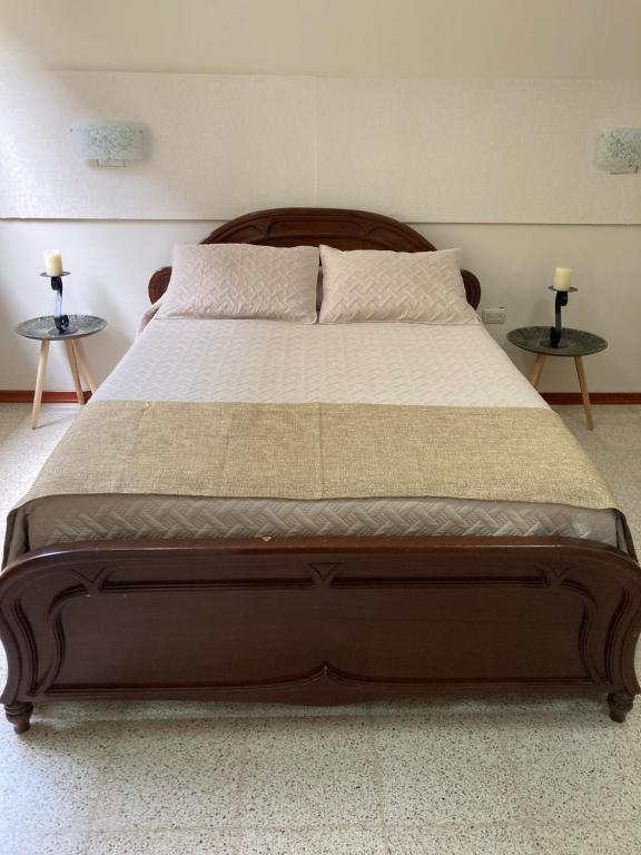 a large bed in a bedroom with two tables at Habitacion Independiente in Guayaquil