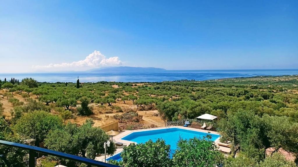 an aerial view of a swimming pool with the ocean at Hilltop Resort at Kefalonia in Angón