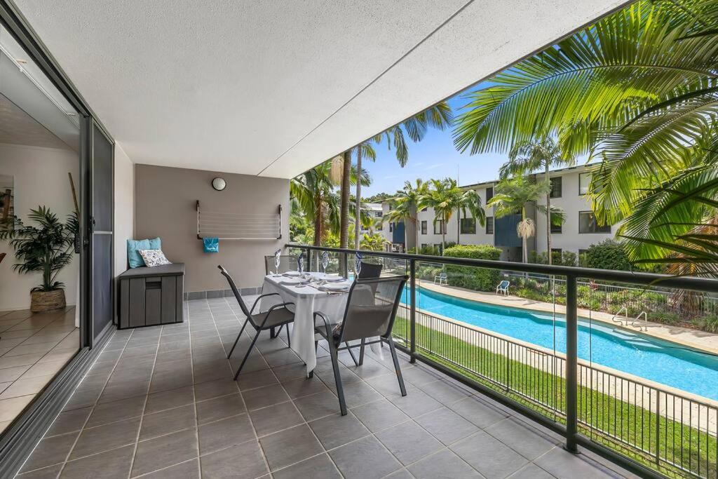 a balcony with a table and chairs and a pool at Your place. Enjoy the beach retreat in Rainbow Beach