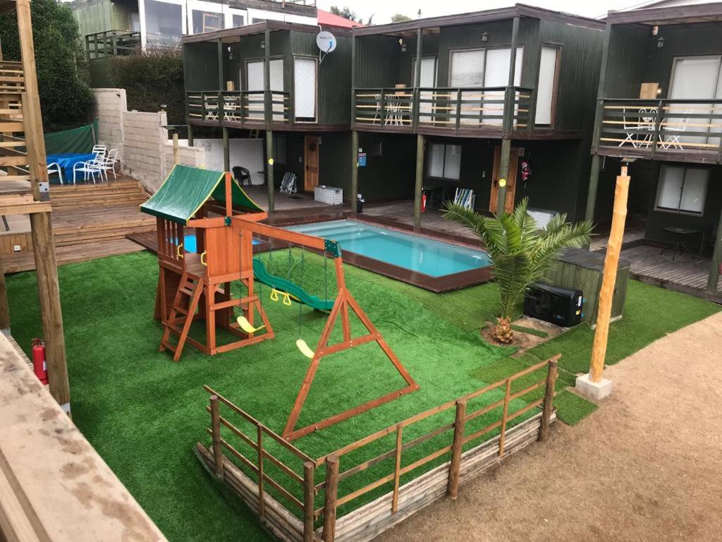 Casa con patio trasero con piscina y parque infantil en Cabañas Arenita, en Maitencillo