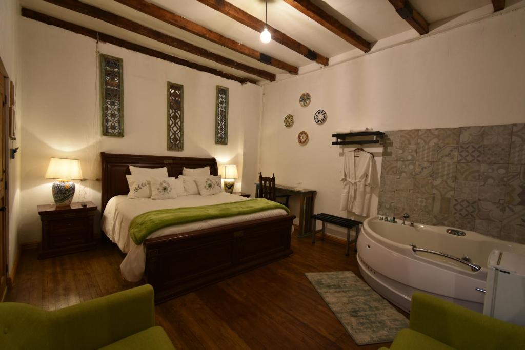 a bedroom with a bed and a bath tub at Casa Morasan Hotel-Boutique in Quetzaltenango