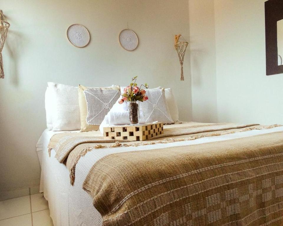 ein Schlafzimmer mit einem Bett mit einer Blumenvase darauf in der Unterkunft Flats Fortal Preá in Prea