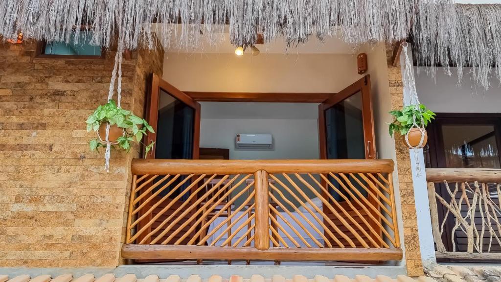 a wooden entrance to a house with a thatch roof at Acoara Beco Doce in Jericoacoara