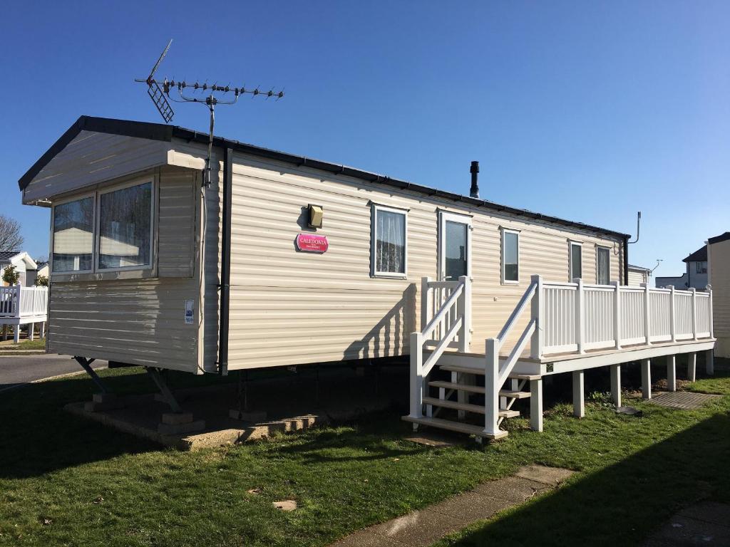 une petite maison avec un escalier sur l'herbe dans l'établissement Solent Breezes, Caravan 108, à Southampton