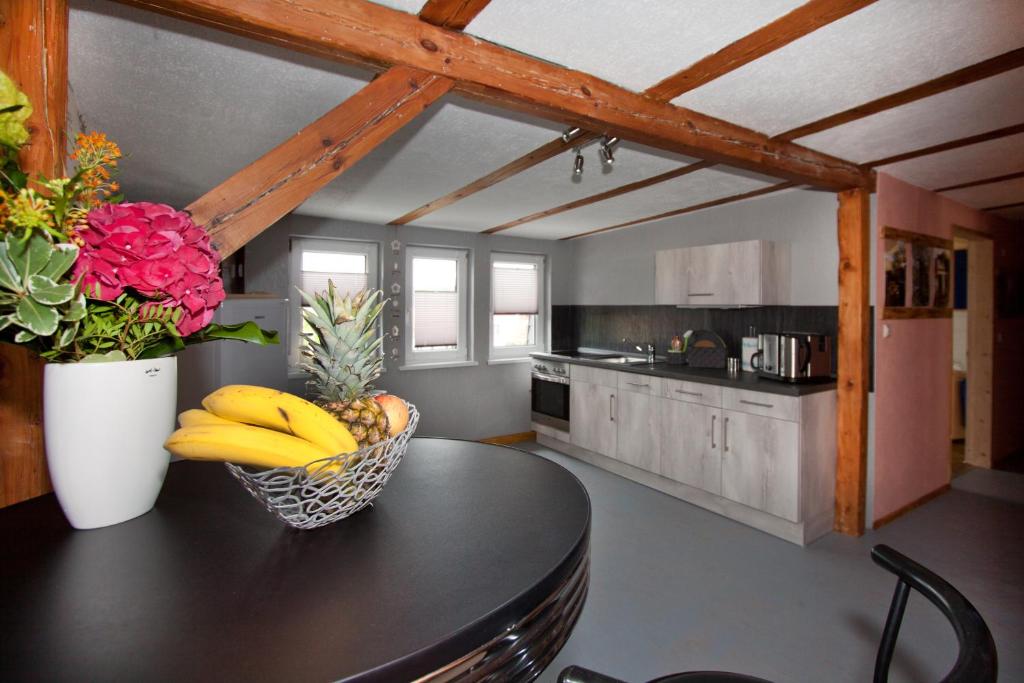 a kitchen with a table with bananas and flowers on it at Ferienwohnung Uwe's Sporthütte in Thale
