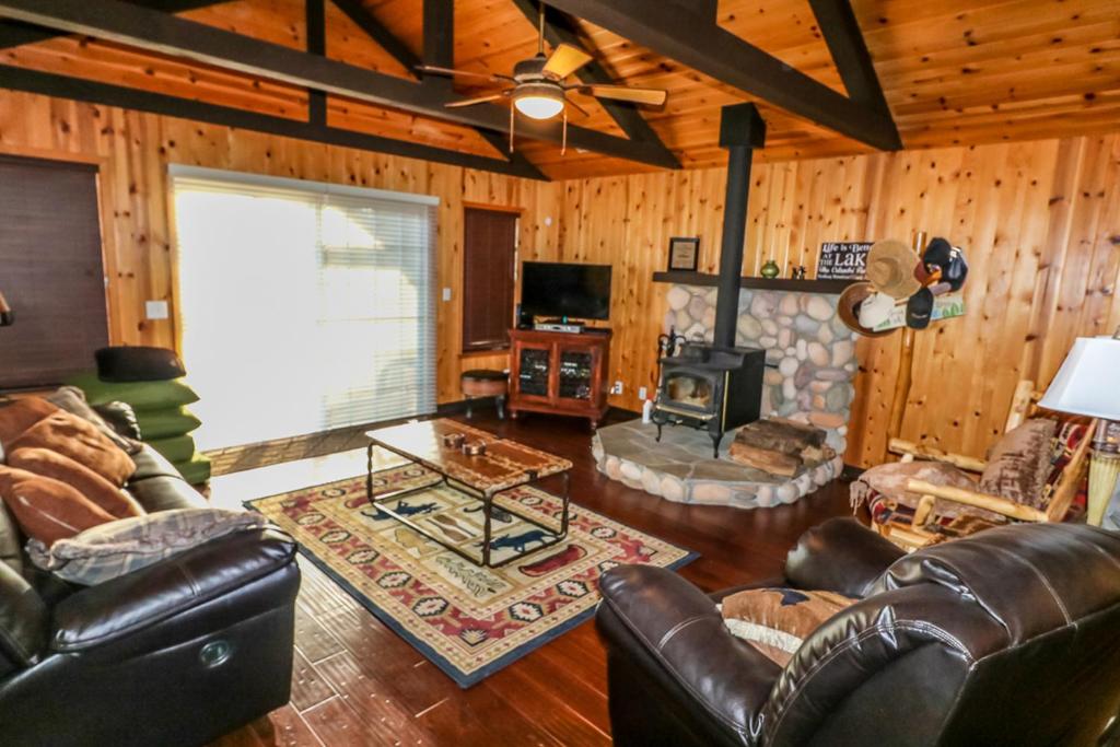 a living room with leather furniture and a fireplace at Calandri Lakeview House in Bass Lake