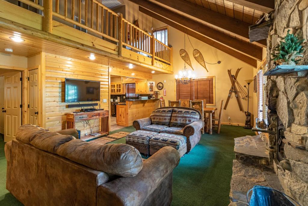 a living room with a leather couch and a television at Yosemite Silvertip Lodge in Fish Camp