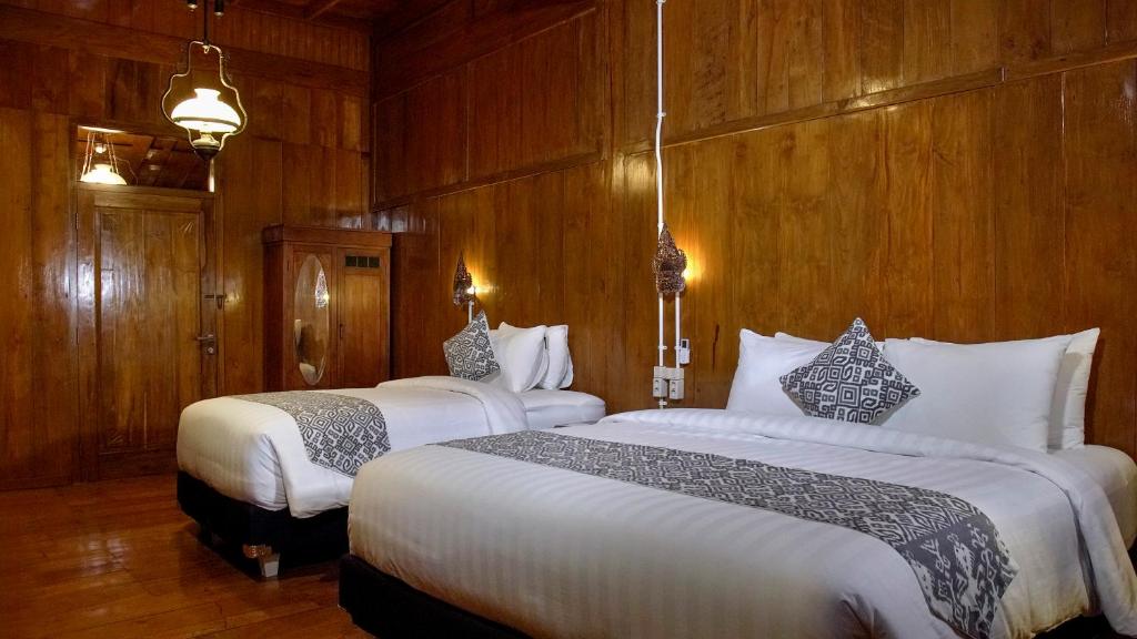 Postel nebo postele na pokoji v ubytování Kampoeng Joglo Boutique Hotel